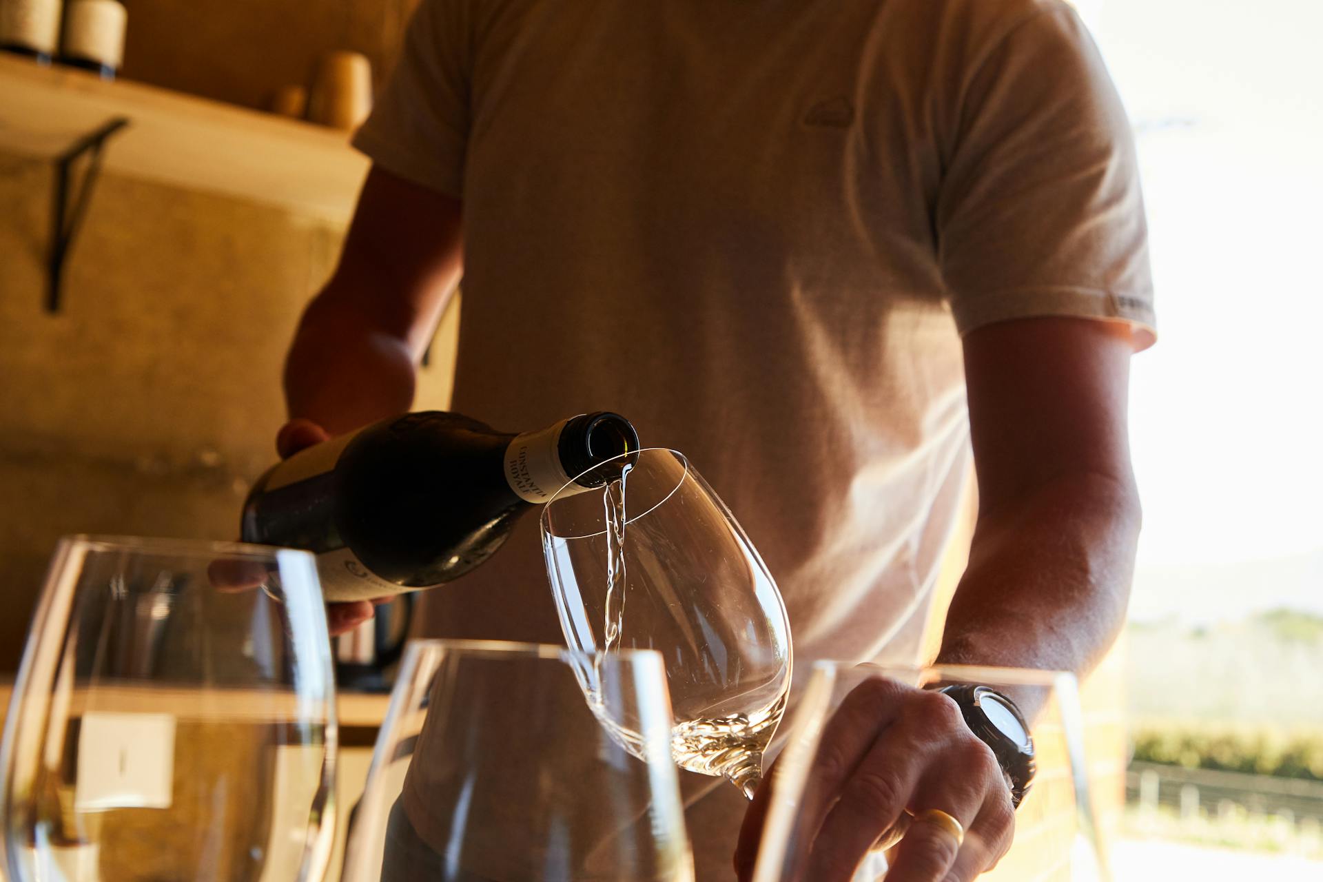 Person pouring a glass of wine