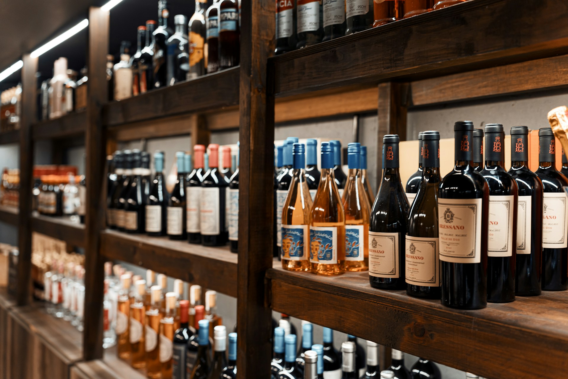 Expensive wines and cheap wines sitting shoulder to shoulder on a shelf